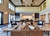 Thumbnail 21 of 80 - A large, modern living room with a brown leather sofa and a coffee table in the center.