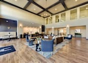 Thumbnail 22 of 80 - A spacious living room with a dark wood floor and a mix of blue and white furniture.