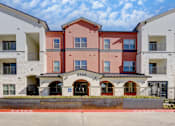 Thumbnail 24 of 80 - The front of apartment building 65004 with a red brick facade and white balconies.