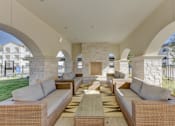 Thumbnail 26 of 80 - A patio with a woven couch and a table in the middle.