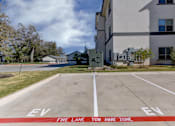 Thumbnail 61 of 80 - A parking lot with the words "EV" and "Fire Lane" painted on the pavement.
