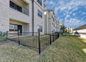 Thumbnail 33 of 80 - A black metal fence in front of a building with a grassy area.