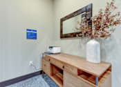Thumbnail 42 of 80 - A wooden desk with a white vase and a mirror on the wall.