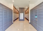 Thumbnail 44 of 80 - A hallway with a row of lockers on the side and a door at the end.