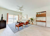Thumbnail 62 of 80 - A living room with a wooden floor and a ceiling fan.