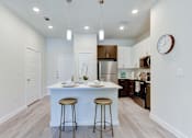 Thumbnail 65 of 80 - A kitchen with a white island and bar stools.