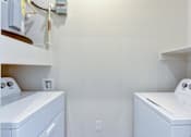 Thumbnail 66 of 80 - Two white washing machines in a small laundry room.