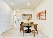 Thumbnail 69 of 80 - A dining room with a table set for four.
