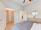 Thumbnail 74 of 80 - A bedroom with a bed, dresser, and a mirror on the wall.