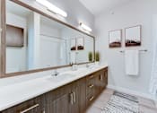 Thumbnail 77 of 80 - A bathroom with a white countertop and brown cabinets.