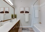 Thumbnail 78 of 80 - A bathroom with a white tub, sink, and mirror.