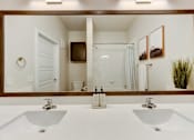 Thumbnail 79 of 80 - A bathroom with two sinks and a large mirror.