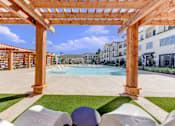 Thumbnail 56 of 80 - A wooden pergola over a pool with white chairs underneath.