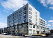 Thumbnail 1 of 15 - A modern building with a glass facade and a sign that reads "The Service Center.".