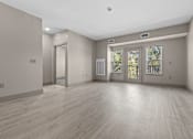 Thumbnail 38 of 39 - A room with wooden floors and a door leading outside.