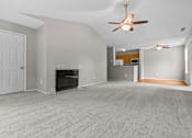 Thumbnail 1 of 40 - A spacious living room with a fireplace and a ceiling fan.
