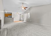 Thumbnail 29 of 40 - A spacious room with a ceiling fan and carpeted floor.