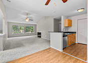 Thumbnail 25 of 40 - A spacious kitchen and living room with a ceiling fan and a large window.