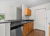Thumbnail 22 of 40 - A kitchen with a black counter top and white appliances.