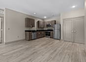 Thumbnail 32 of 39 - A kitchen with wooden floors and stainless steel appliances.