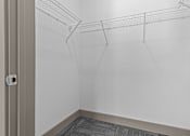 Thumbnail 29 of 39 - Empty walk-in closet with a grey carpet.