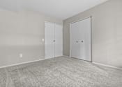 Thumbnail 20 of 40 - A room with two doors and carpeted floor.