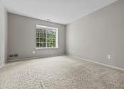 Thumbnail 21 of 40 - A room with a window and carpeted floor.