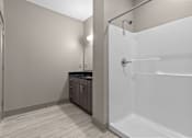 Thumbnail 28 of 39 - A white bathroom with a walk-in shower and a vanity.