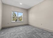 Thumbnail 27 of 39 - A room with a large window and a grey carpet.