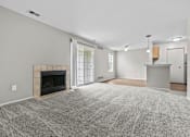 Thumbnail 35 of 40 - A spacious living room with a fireplace and a grey carpet.