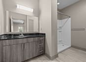 Thumbnail 23 of 39 - A bathroom with a sink, mirror, and shower.