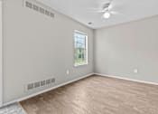 Thumbnail 28 of 40 - Empty room with a window and a ceiling fan.