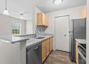 Thumbnail 18 of 40 - A kitchen with a black dishwasher and a white refrigerator.