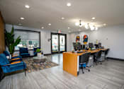 Thumbnail 27 of 57 - A modern office space with a reception desk and chairs.