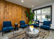 Thumbnail 7 of 57 - A living room with blue chairs and a wooden wall.