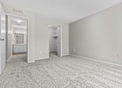 Thumbnail 23 of 40 - A spacious room with grey carpeting and two doors.