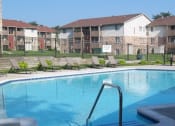 Thumbnail 5 of 14 - Brighton Cove outdoor pool. Expansive sundeck with lounge chairs. Brighton Cove in the background.