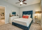 Thumbnail 54 of 57 - A bedroom with a bed, nightstand, and a ceiling fan.
