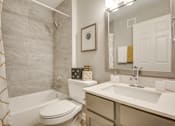 Thumbnail 42 of 57 - A bathroom with a white toilet, a white sink, and a shower curtain.