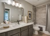 Thumbnail 39 of 57 - A bathroom with a white counter top and a large mirror above it.