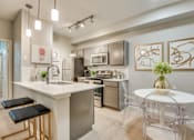 Thumbnail 12 of 57 - A modern kitchen with a white island and black bar stools.