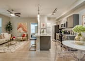 Thumbnail 45 of 57 - A modern kitchen with a bar stool and a dining table with chairs.