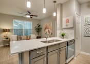 Thumbnail 48 of 57 - A kitchen with a white countertop and a ceiling fan.