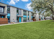 Thumbnail 6 of 57 - A grassy area in front of apartment buildings.