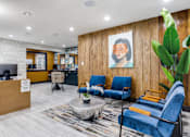 Thumbnail 8 of 57 - A reception area with blue chairs and a wooden wall.