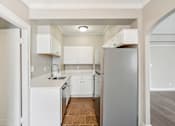 Thumbnail 57 of 66 - A kitchen with white appliances and cabinets.