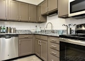 Thumbnail 9 of 18 - a kitchen with stainless steel appliances and granite counter tops