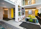 Thumbnail 14 of 47 - a living room with yellow walls and a green couch at Ann Arbor City Club, Michigan, 48104