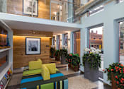 Thumbnail 17 of 47 - the lobby of a building with a colorful couch and plants at Ann Arbor City Club, Ann Arbor, 48104