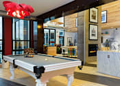 Thumbnail 14 of 26 - A pool table in a room with a fireplace and a fire burning.